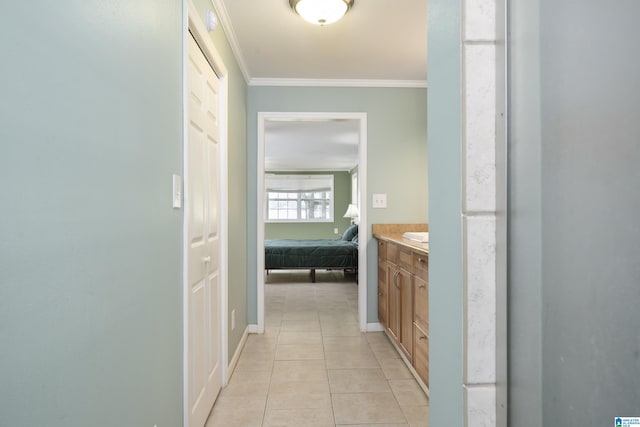 bathroom with crown molding, tile patterned floors, baseboards, and vanity