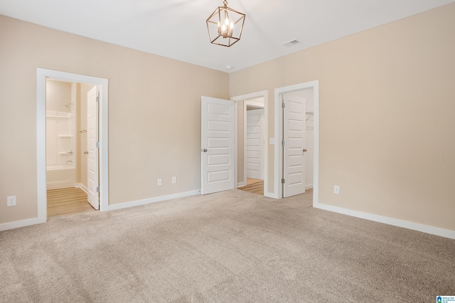 3769 Seaside Sparrow Cir, Bessemer, AL 35022 - unfurnished bedroom with carpet flooring, a chandelier, visible vents, baseboards, and a walk in closet