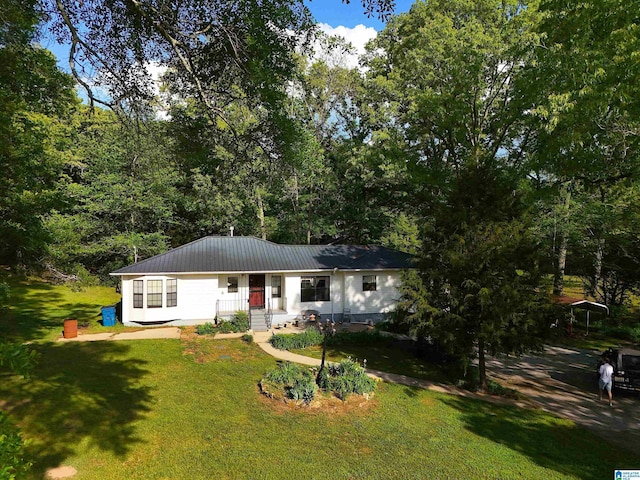 ranch-style home with metal roof, a front lawn, and covered porch