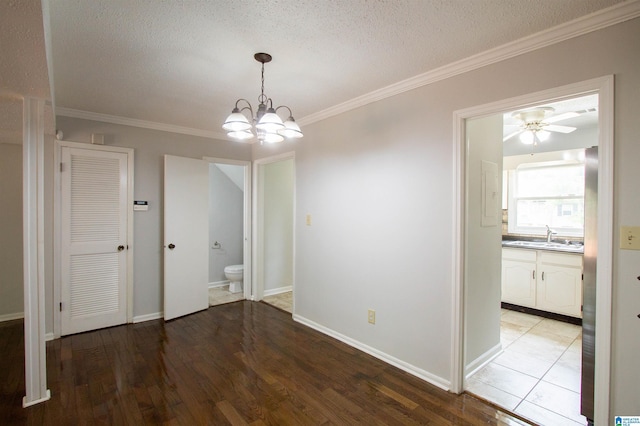 302 Old Rocky Ridge Ln, Birmingham, AL 35216 - unfurnished dining area with a textured ceiling, light wood-style floors, crown molding, and a sink