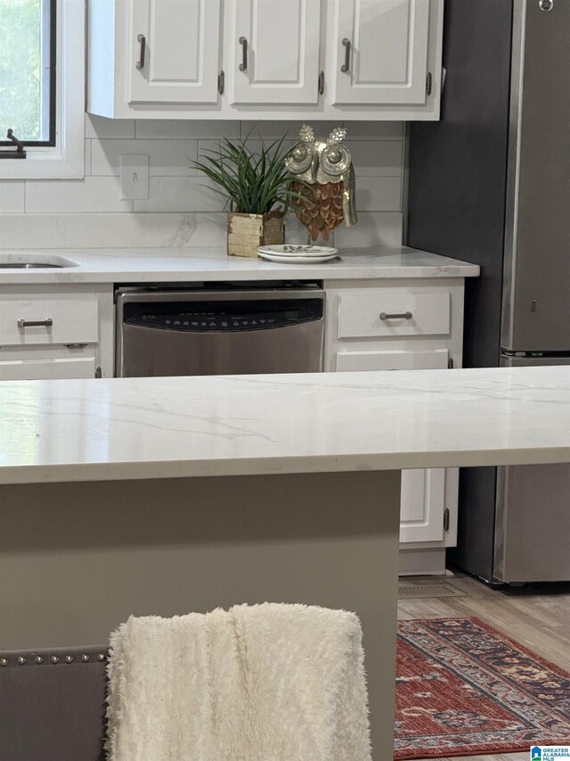5600 Double Tree Cir, Birmingham, AL 35242 - kitchen with appliances with stainless steel finishes, white cabinetry, light wood-style floors, and a sink