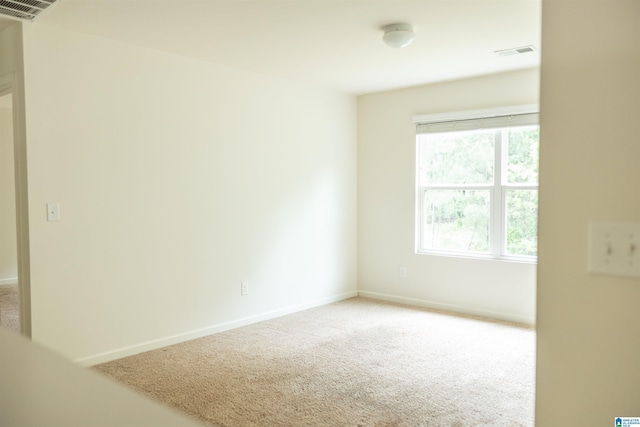 spare room featuring carpet flooring and baseboards