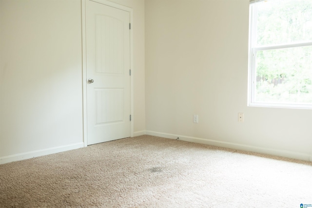 unfurnished room featuring carpet and baseboards