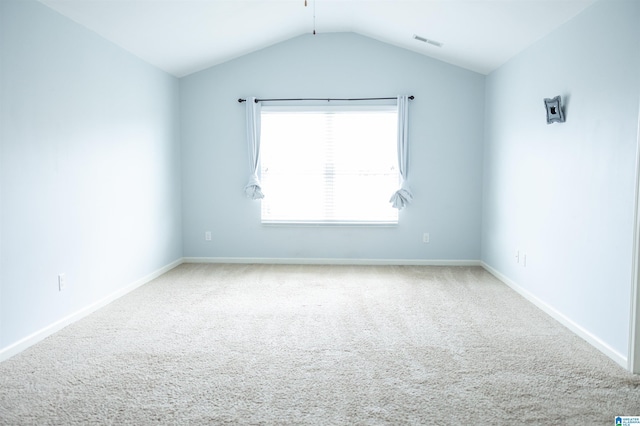 unfurnished room featuring carpet, vaulted ceiling, and baseboards