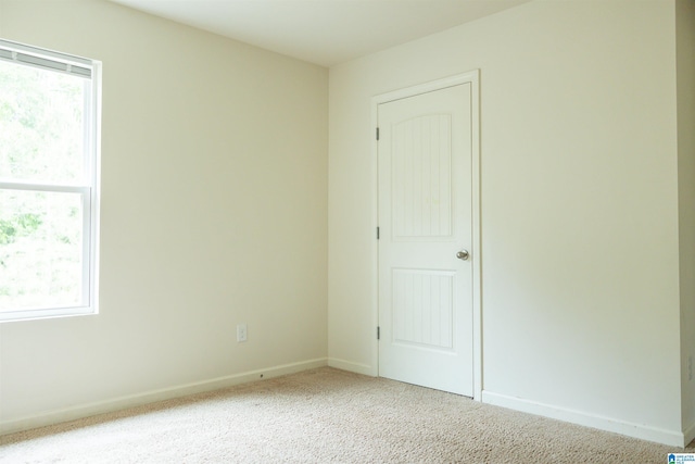 carpeted spare room featuring baseboards