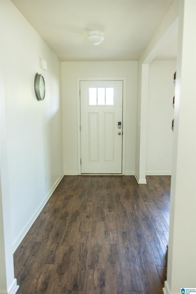 doorway to outside with dark wood-type flooring and baseboards