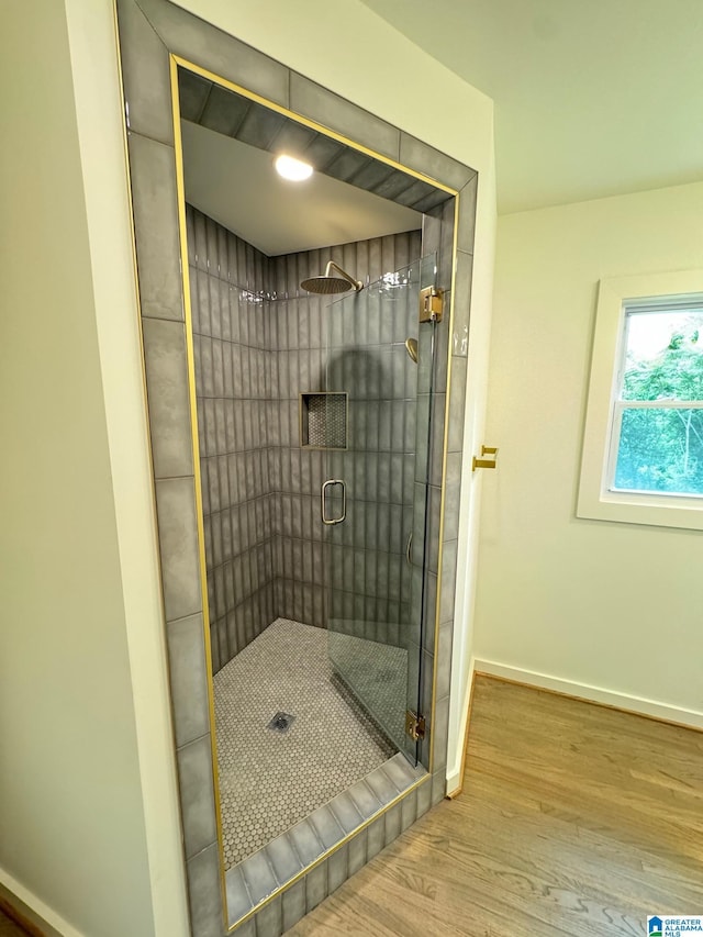 full bathroom with baseboards, wood finished floors, and a stall shower