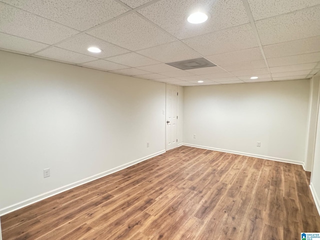 finished basement with a paneled ceiling, recessed lighting, baseboards, and wood finished floors