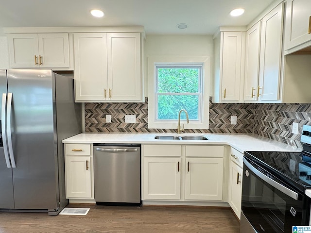 kitchen featuring stainless steel appliances, white cabinetry, and a sink