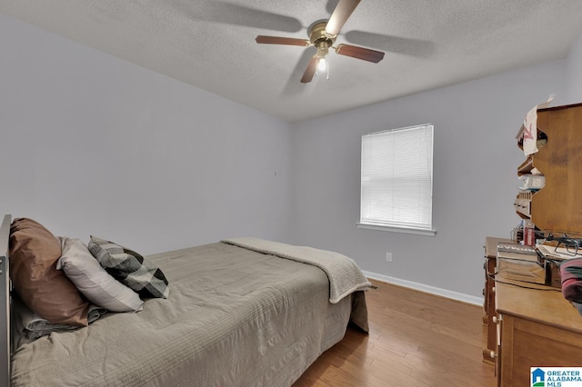 135 Hayden Springs Rd, Hayden, AL 35079 - bedroom with a textured ceiling, a ceiling fan, light wood-style flooring, and baseboards