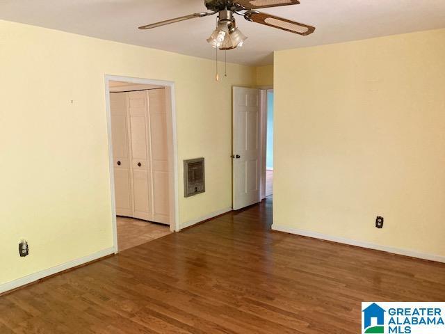 4905 Spunky Hollow Rd, Remlap, AL 35133 - empty room featuring baseboards, wood finished floors, a ceiling fan, and heating unit