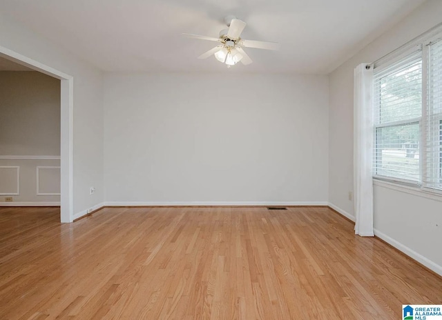 spare room featuring baseboards, visible vents, ceiling fan, and light wood-style floors