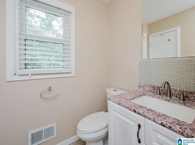 bathroom featuring tasteful backsplash, visible vents, toilet, and vanity