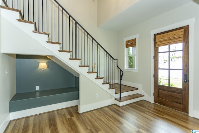 entrance foyer featuring stairway, baseboards, and wood finished floors