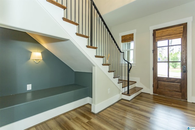 entrance foyer with baseboards, stairs, and wood finished floors