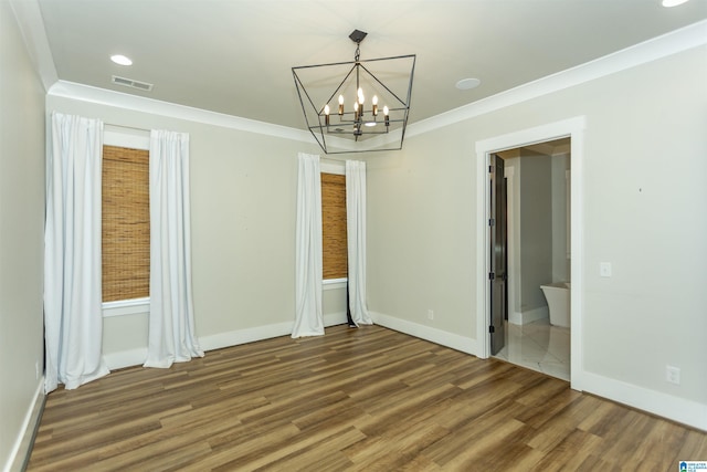 unfurnished dining area with an inviting chandelier, baseboards, wood finished floors, and visible vents