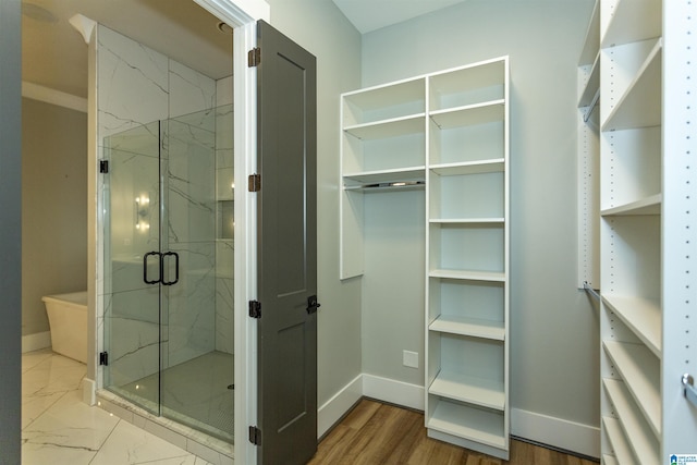 full bathroom featuring baseboards, a marble finish shower, and marble finish floor