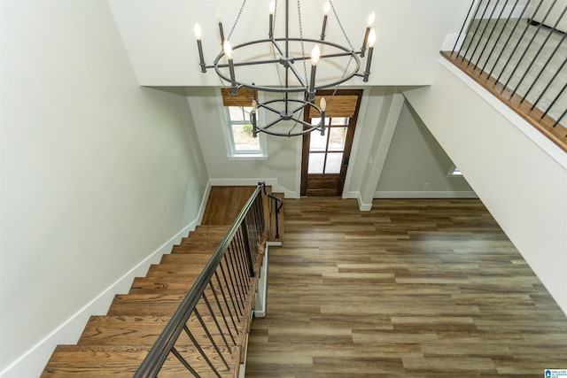 foyer with stairs, baseboards, a chandelier, and wood finished floors