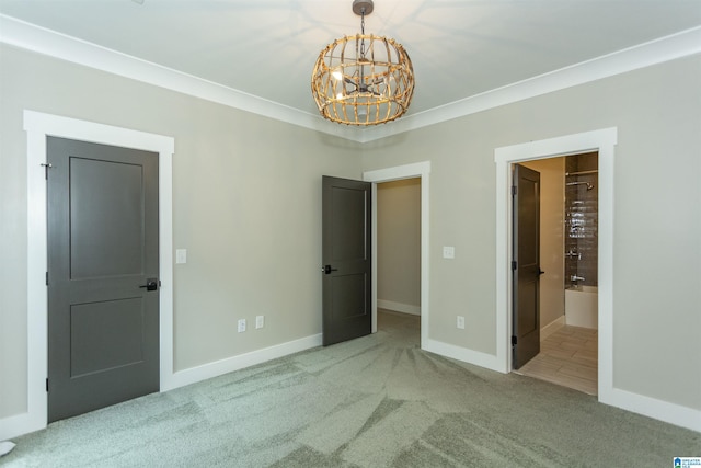 unfurnished bedroom featuring baseboards, carpet flooring, ensuite bath, and a chandelier
