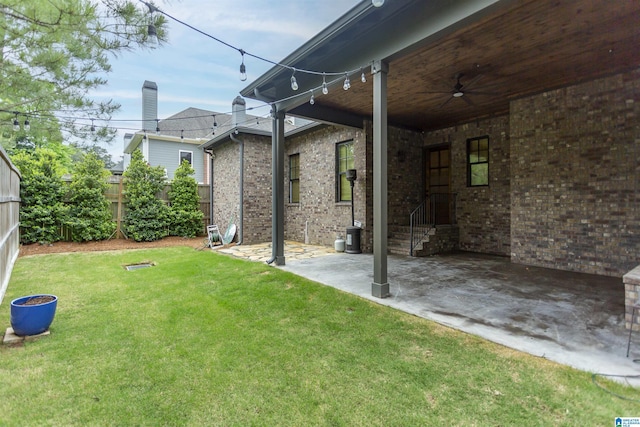 view of yard with a fenced backyard, a ceiling fan, and a patio