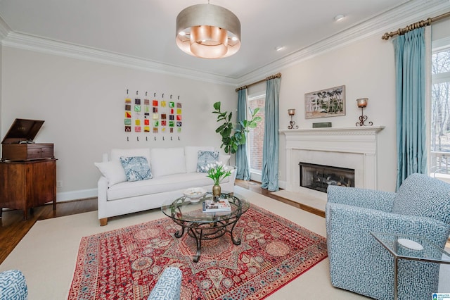 living room with crown molding, baseboards, a high end fireplace, and wood finished floors