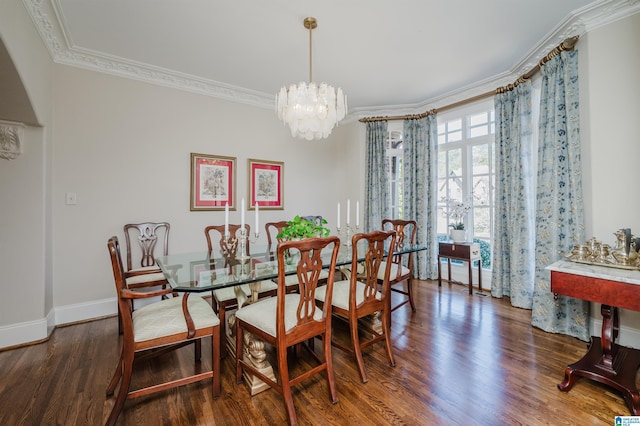 dining room with baseboards, ornamental molding, wood finished floors, and a chandelier