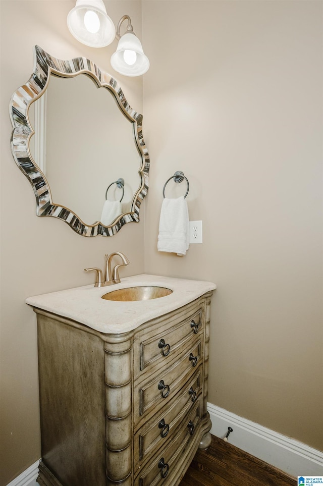 bathroom featuring vanity, baseboards, and wood finished floors