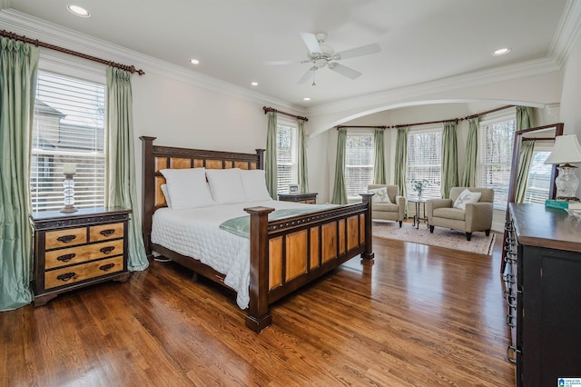 bedroom featuring dark wood-type flooring, ornamental molding, and multiple windows