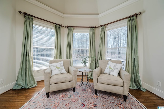 living area featuring baseboards, ornamental molding, and wood finished floors