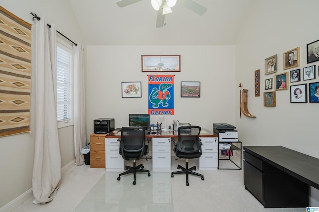office space with baseboards, ceiling fan, and vaulted ceiling