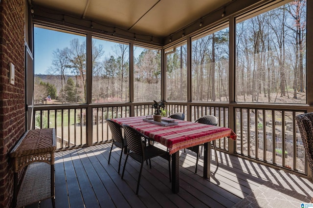 sunroom featuring outdoor dining area and plenty of natural light