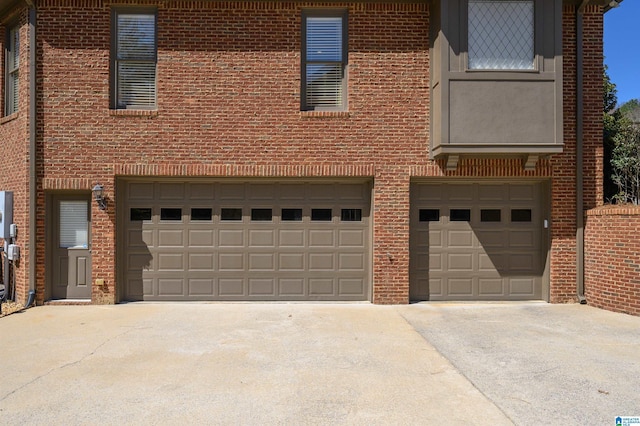 view of front facade featuring brick siding, an attached garage, and driveway
