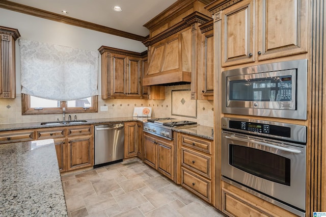 kitchen featuring brown cabinets, appliances with stainless steel finishes, light stone counters, a sink, and ornamental molding