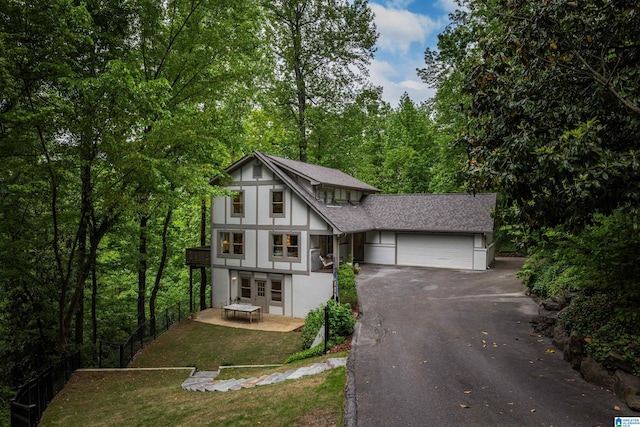 view of front of property featuring fence, a front lawn, a garage, stucco siding, and driveway