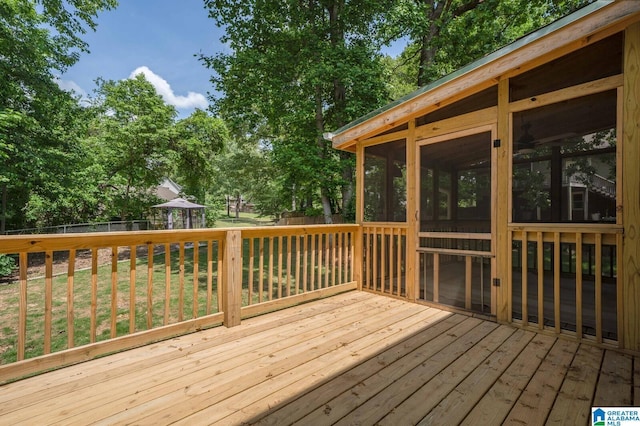 deck featuring a sunroom, a fenced backyard, and a yard