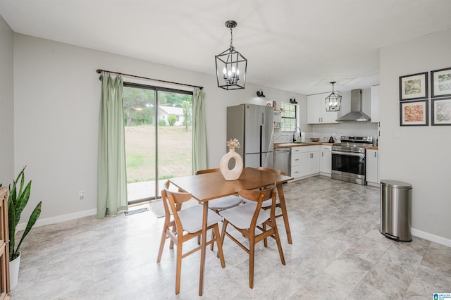 dining room with baseboards, an inviting chandelier, a wealth of natural light, and visible vents