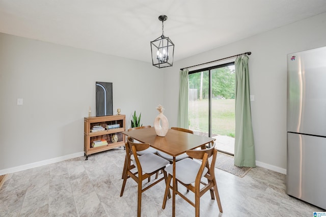 dining space featuring baseboards and a notable chandelier