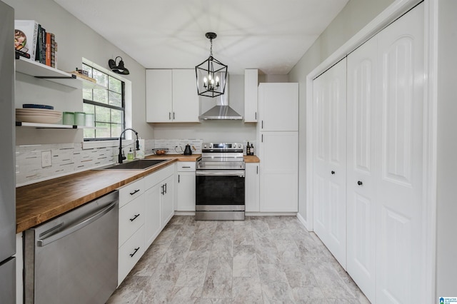 kitchen featuring open shelves, a sink, a chandelier, wooden counters, and stainless steel appliances