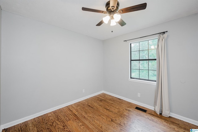 unfurnished room featuring baseboards, ceiling fan, wood finished floors, and visible vents