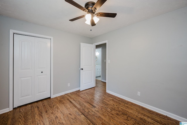 unfurnished bedroom with baseboards, ceiling fan, a closet, and wood finished floors