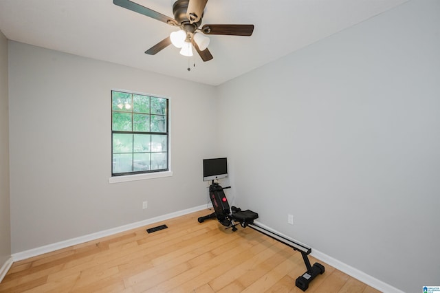 exercise area featuring visible vents, a ceiling fan, baseboards, and hardwood / wood-style flooring