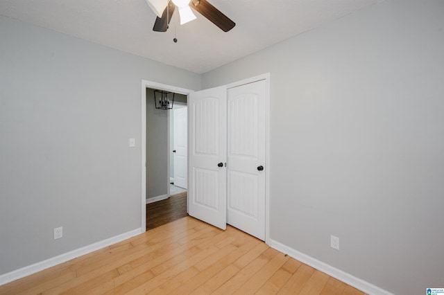 unfurnished bedroom with baseboards, ceiling fan, a closet, and light wood-type flooring