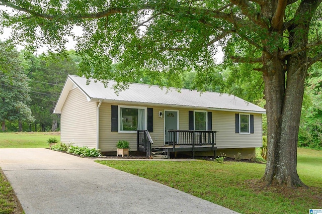 single story home featuring covered porch, metal roof, and a front yard
