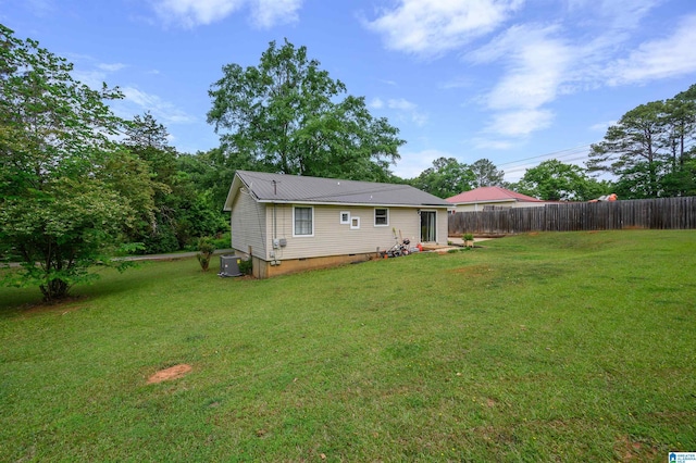 back of property featuring a lawn, central AC unit, fence, and crawl space