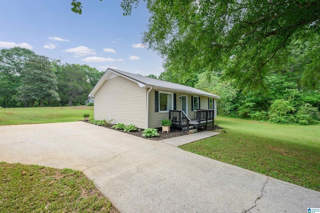 single story home featuring a porch, a front yard, and concrete driveway
