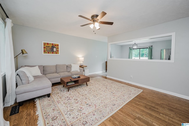 living room with baseboards, ceiling fan, and wood finished floors
