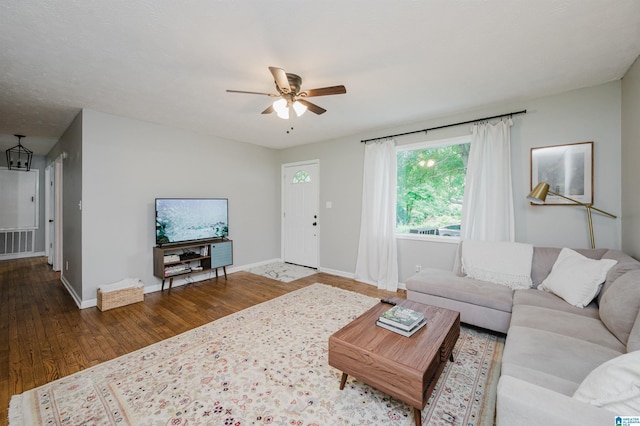 living room with baseboards, ceiling fan, wood finished floors, and visible vents