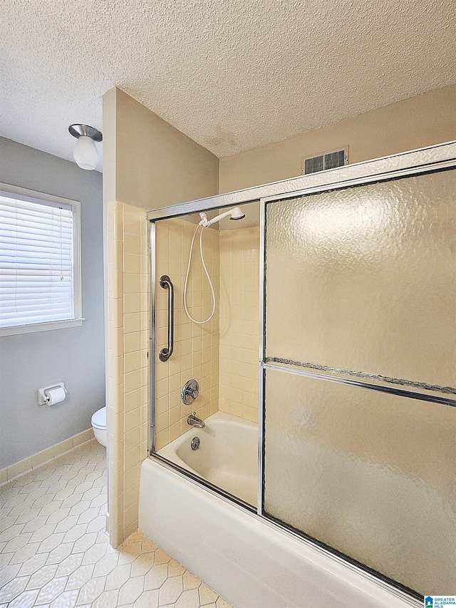 574 Turtle Creek Dr, Hoover, AL 35226 - bathroom featuring toilet, tile patterned flooring, bath / shower combo with glass door, pet washing area, and a textured ceiling