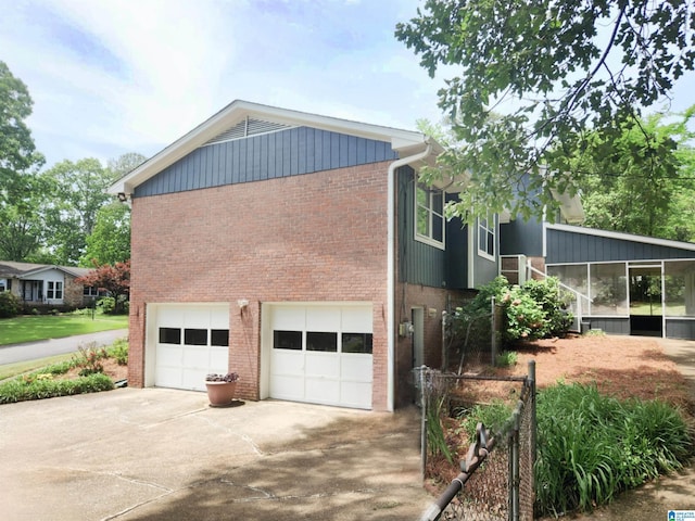 574 Turtle Creek Dr, Hoover, AL 35226 - view of side of property with brick siding, driveway, an attached garage, and a sunroom