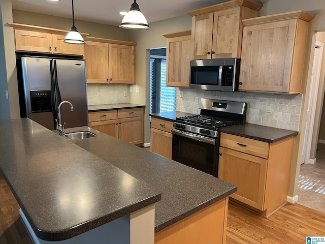 2128 Rockland Dr, Hoover, AL 35226 - kitchen featuring stainless steel appliances, a sink, dark countertops, light brown cabinetry, and a large island with sink